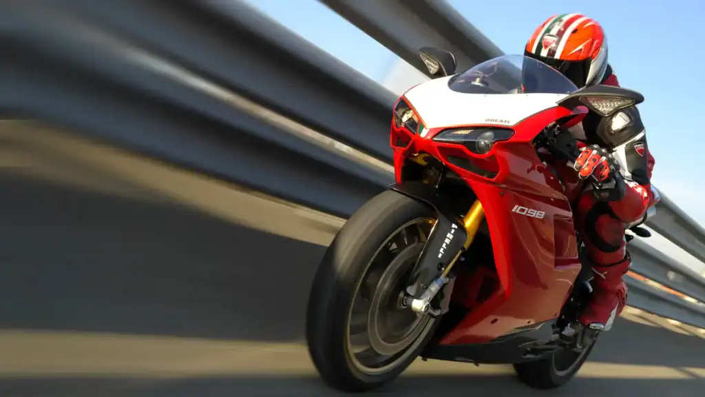 Red and white sport motorcycle racing on track.